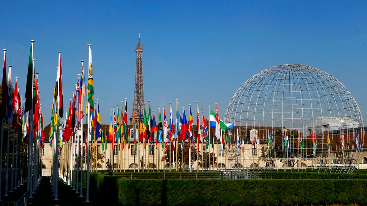 FILE - In this Tuesday Oct. 31, 2017 file picture, the Eiffel Tower, country flags and the Dome are seen from the garden of the United Nations Educational, Scientific and Cultural Organisation (UNESCO) headquarters building during the 39th session of the General Conference at the UNESCO headquarters in Paris, France. The United States and Israel have quit the U.N.’s educational, scientific and cultural agency, arguing the organization fosters anti-Israel bias. (AP Photo/Francois Mori, File)