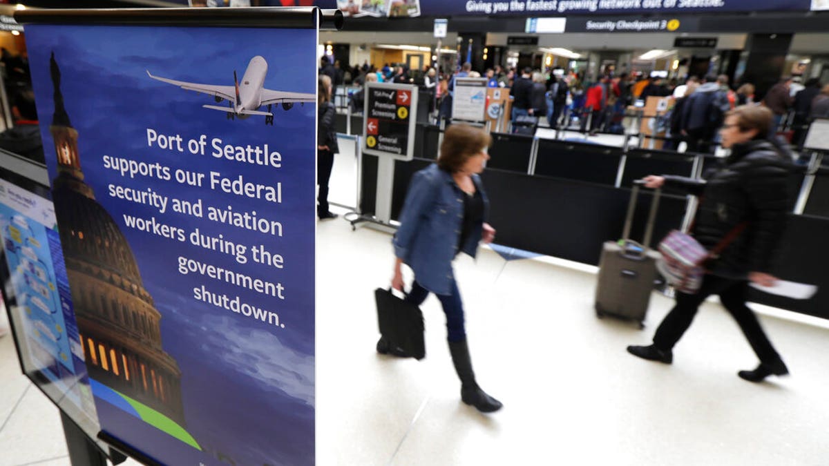 A sign near a TSA security checkpoint states the Port of Seattle's support for federal government workers, Friday, Jan. 25, 2019, in Seattle. Yielding to mounting pressure and growing disruption, President Donald Trump and congressional leaders on Friday reached a short-term deal to reopen the government for three weeks while negotiations continue over the president's demands for money to build his long-promised wall at the U.S.-Mexico border. (AP Photo/Ted S. Warren)