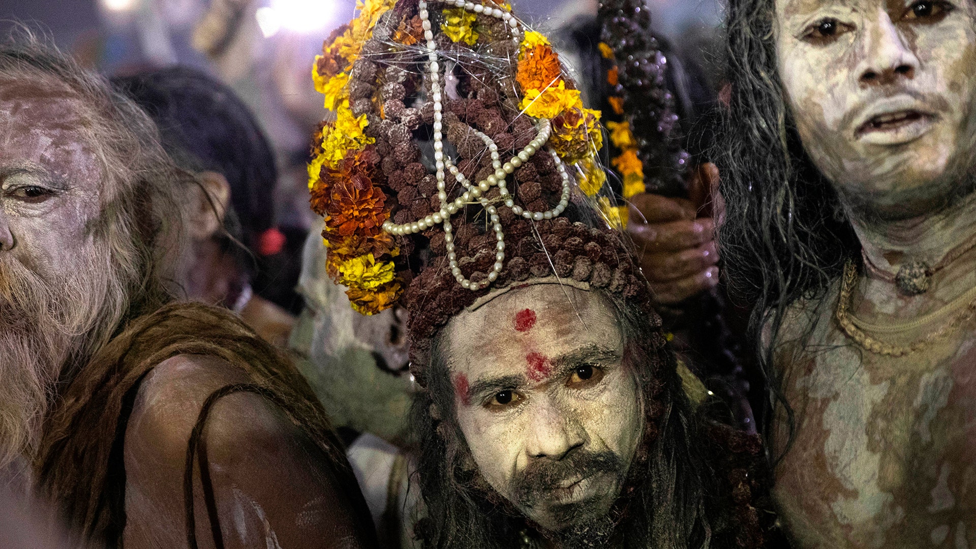 Indian Sadhus, or Hindu holy men, covered in ash walk before taking a ritualistic dip on auspicious Makar Sankranti day during the Kumbh Mela, or pitcher festival in Prayagraj, Uttar Pradesh state, India, Jan. 15, 2019. 