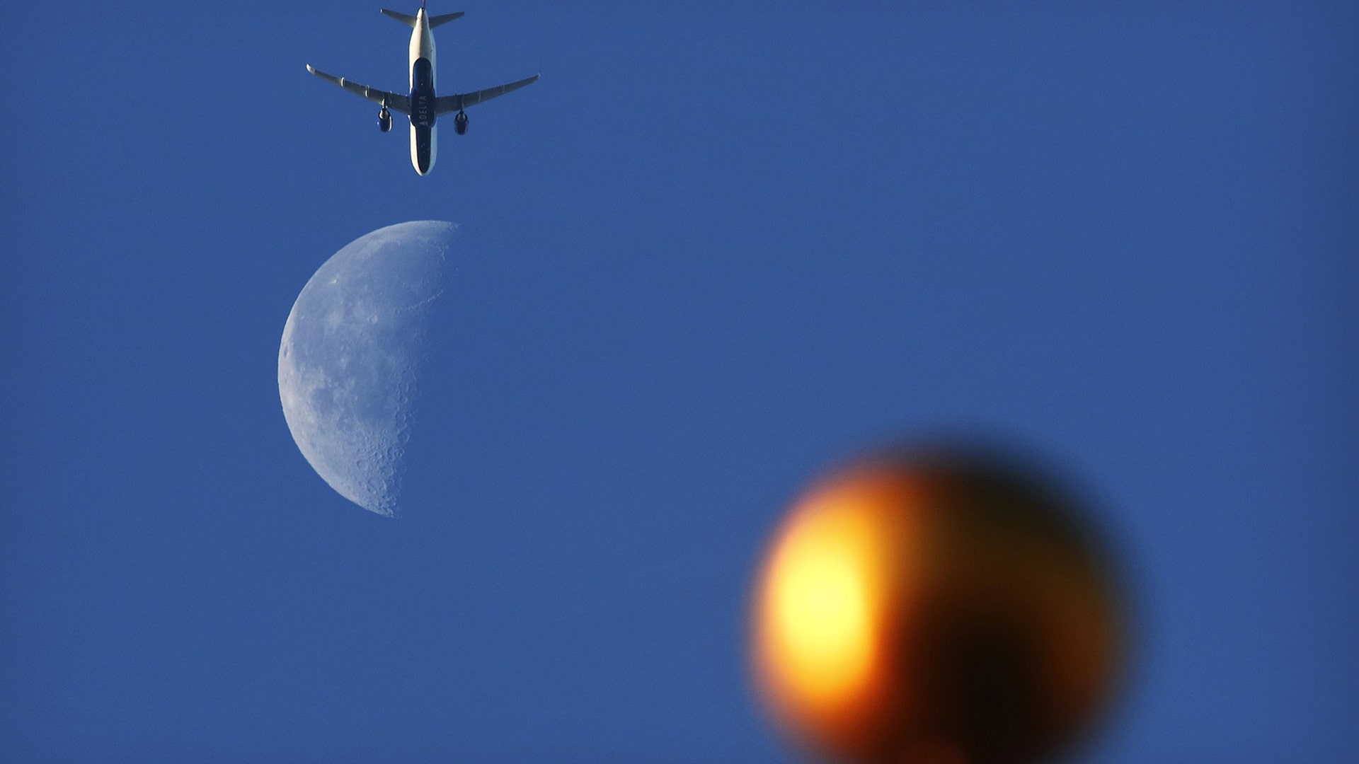 An airplane passed by the moon at sunrise over Jersey City, New Jersey, Dec. 29, 2018.