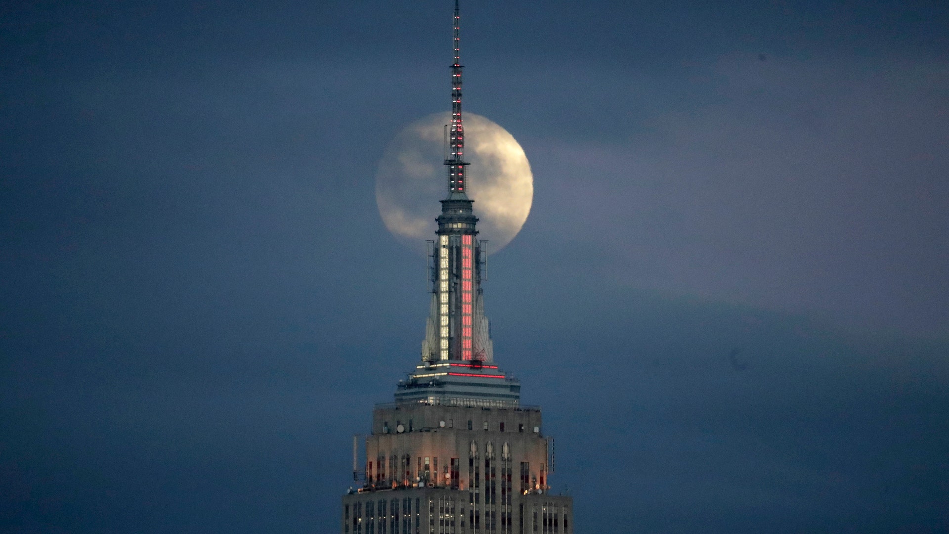 The rare phenomenon was visible in North and South America. In this photo the Moon is seen in its waxing gibbous stage as it rises behind the Empire State Building, Sunday, Jan. 20, 2019, seen from Jersey City, N.J.