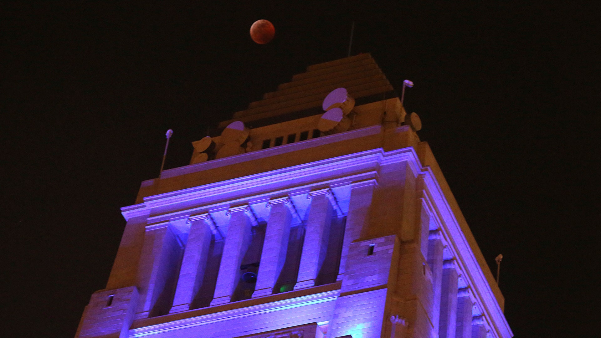 The Moon in total eclipse over Los Angeles City Hall.