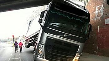 Semi truck gets very stuck under bridge