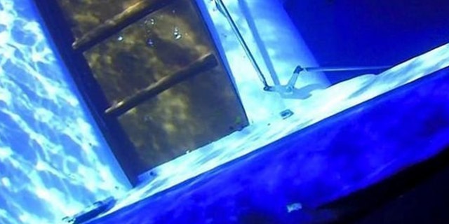 The pictures, taken by the U.S. Coast Guard, show the vessel with open escape hatches and damage to both hulls which prosecutors allege were caused from inside the boat.