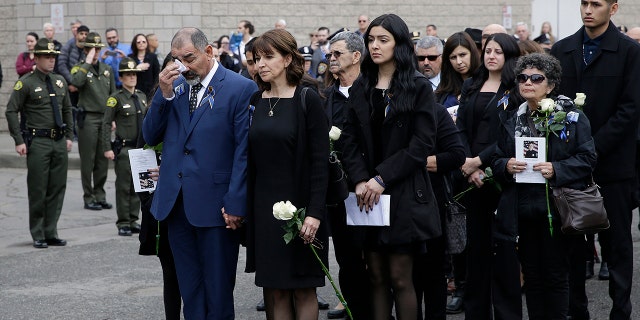 Merced Corona, left, and Lupe Corona, the parents of Davis Police Officer Natalie Corona, watch as her coffin is taken to a hearse after funeral services for Davis Police Officer Natalie Corona at the University of California, Davis, Friday, Jan. 18, 2019, in Davis, Calif. (Associated Press)