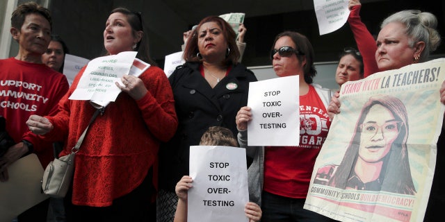 Parents and teachers hold signs while talking to reporters outside Los Angeles Unified School District headquarters Tuesday, Jan. 8, 2019, in Los Angeles. (AP Photo/Jae C. Hong)