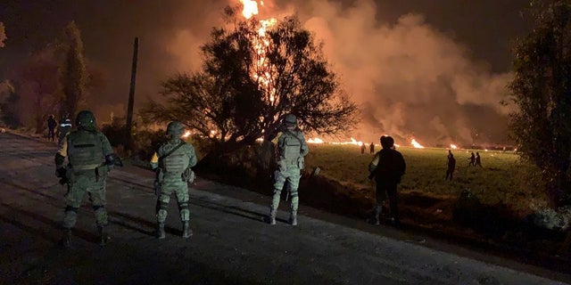 Mexican soldiers guard the area by an oil pipeline explosion in Tlahuelilpan, Hidalgo state, Mexico, Friday, Jan. 18, 2019. (Secretary of National Defense via AP)