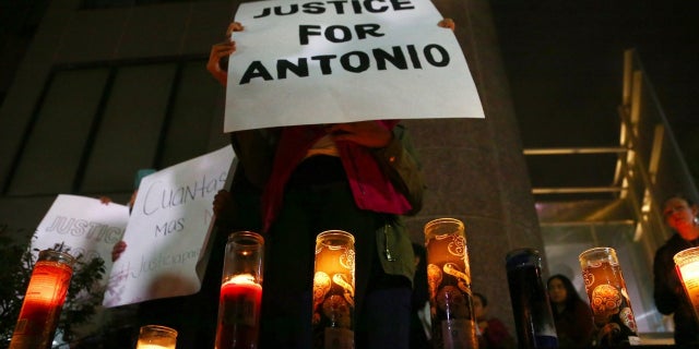 Family members and others stand in front of the Tempe Police headquarters to hold a protest and vigil for a teen boy who was shot to death on Tuesday, Jan. 15, 2019.