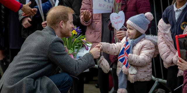 Britain's Prince Harry, with Meghan, Duchess of Sussex, greets the crowds of people during a visit to Birkenhead, northwest England, Monday Jan. 14, 2019. (Charlotte Graham/Pool via AP)