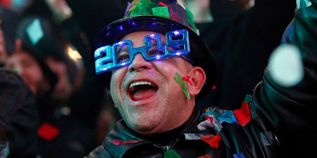 A reveler celebrates as confetti falls during a New Year's celebration in New York's Times Square, Tuesday, Jan. 1, 2019. (AP Photo/Adam Hunger)