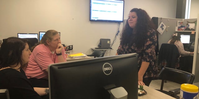 ViaLink coordinators talk as a crisis counselor offers help over the phone.