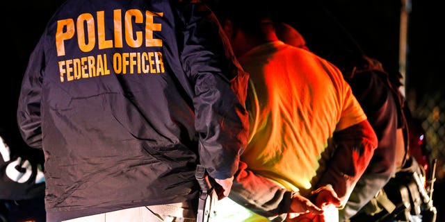 In this Oct. 22, 2018, photo U.S. Immigration and Customs Enforcement agents surround and detain a person during a raid in Richmond, Va. ICE's enforcement and removal operations