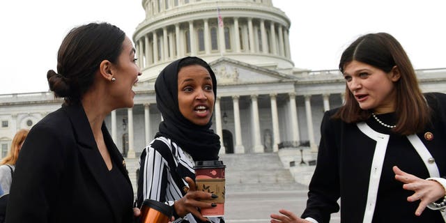 Rep. Alexandria Ocasio-Cortez, D-N.Y., left, talks with Rep. Ilhan Omar, D-Minn., center, and Rep. Haley Stevens, D-Mich., as they head to a group photo with the women of the 116th Congress on Capitol Hill last Friday. (AP Photo/Susan Walsh)
