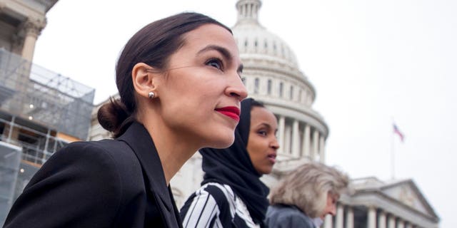 Rep. Alexandria Ocasio-Cortez, left, and D-N.Y., Rep. Ilhan Omar, D-Minn., center, walk down the House steps.