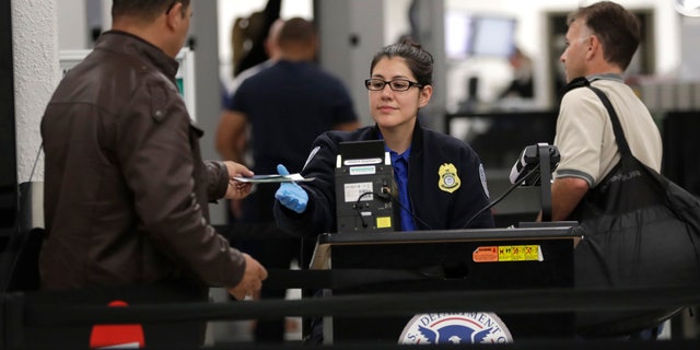 A Transportation Security Administration officer works at a checkpoint at Miami International Airport, Sunday, Jan. 6, 2019, in Miami. The TSA acknowledged an increase in the number of its employees calling off work during the partial government shutdown. (AP Photo/Lynne Sladky)