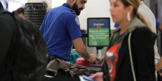 A Transportation Security Administration officer works at a checkpoint at Miami International Airport, Sunday, Jan. 6, 2019, in Miami. The TSA acknowledged an increase in the number of its employees calling off work during the partial government shutdown.