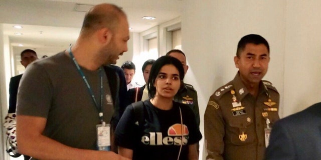 In this photo released by the Immigration Police, Chief of Immigration Police Maj. Gen. Surachate Hakparn, right, walks with Saudi woman Rahaf Mohammed Alqunun before leaving the Suvarnabhumi Airport in Bangkok Monday, Jan. 7, 2019. A Saudi woman who says she is fleeing abuse by her family and wants asylum in Australia has sent out desperate pleas for help over social media. Rahaf Mohammed Alqunun, 18, began posting on Twitter late Saturday after her passport was taken away when she arrived on a flight from Kuwait. (Immigration police via AP)