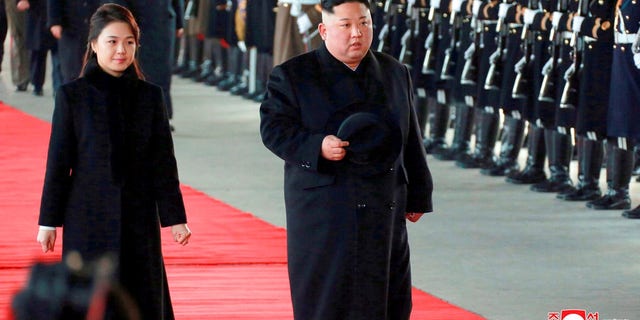 North Korean leader Kim Jong Un walks with his wife Ri Sol Ju at Pyongyang Station in Pyongyang, North Korea, before leaving for China.