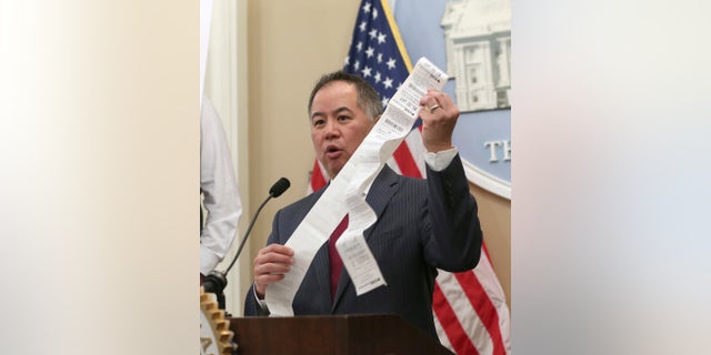 Assemblyman Phil Ting, D-San Francisco, displays a long paper receipt as he discusses his bill to require businesses to offer electronic receipts, Tuesday, Jan. 8, 2019, in Sacramento, Calif.