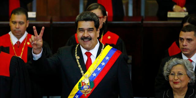 Venezuela's President Nicolas Maduro makes a victory sign during his swearing-in ceremony at the Supreme Court in Caracas, Venezuela, Thursday, Jan. 10, 2019. 