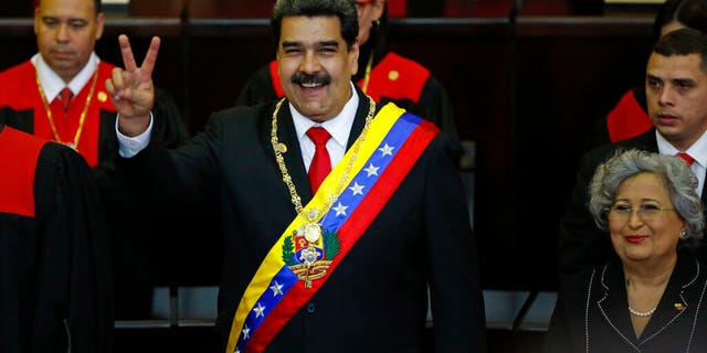 Venezuela's President Nicolas Maduro makes a victory sign during his swearing-in ceremony at the Supreme Court in Caracas, Venezuela, Thursday, Jan. 10, 2019.