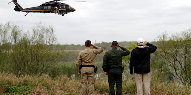 President Donald Trump salutes as he tours the U.S. border with Mexico at the Rio Grande on the southern border, Thursday, Jan. 10, 2019, in McAllen, Texas. (AP Photo/ Evan Vucci)