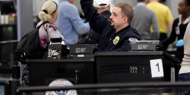 A Transportation Security Administration officer works at the entrance to Concourse G at Miami International Airport, Friday, Jan. 11, 2019, in Miami. The airport is closing Terminal G this weekend as the federal government shutdown stretches toward a fourth week because security screeners have been calling in sick at twice the airport's normal rate.