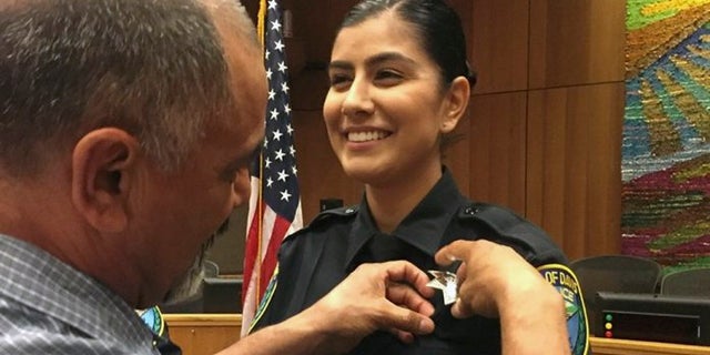 Merced Corona pins his daughter Natalie Corona's badge on her uniform during a swearing-in ceremony in Davis, Calif., on Aug. 2, 2018. (Williams Pioneer Review via AP)