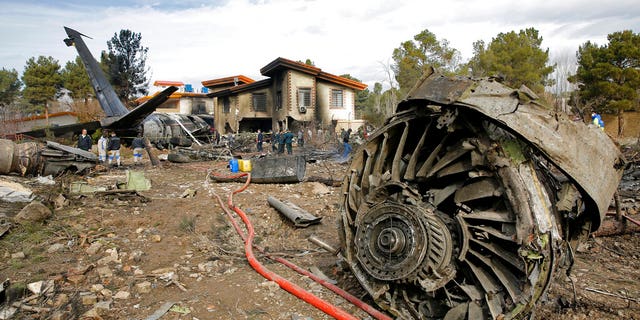 Iranian rescue personnel and security work at the site of a Boeing 707 cargo plane crash, at Fath Airport about 25 west of Tehran, Iran.