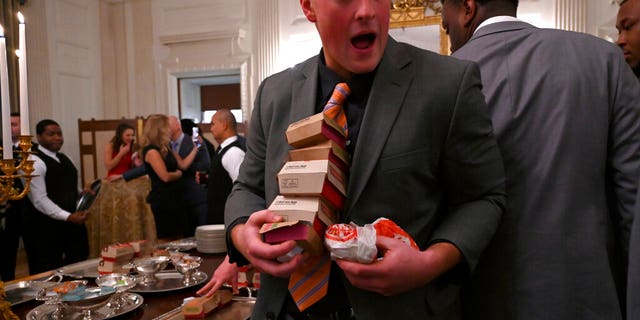 Guests attending a reception for the Clemson Tigers grab fast food sandwiches in the State Dining Room of the White House in Washington, Monday, Jan. 14, 2019. (AP Photo/Susan Walsh)