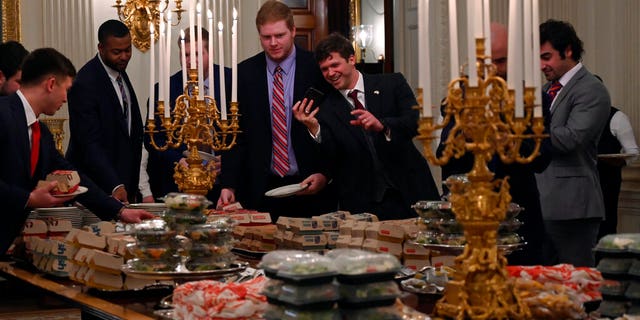 Guests attending a reception for the Clemson Tigers grab fast food sandwiches in the State Dining Room of the White House in Washington, Monday, Jan. 14, 2019. (AP Photo/Susan Walsh)