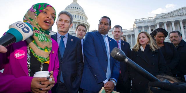 Rep. Ilhan Omar, D-Minn., left, Rep. Mike Levin, D-Calif., Rep. Christopher Pappas, D-N.H., Rep. Joe Neguse, D-Colo., and other freshmen member of the House of Representatives speak about the government shutdown on Capitol Hill, Tuesday, Jan. 15, 2019 in Washington. (AP Photo/Alex Brandon)