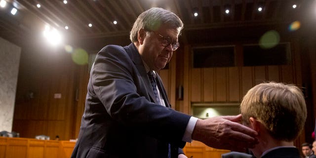 Attorney General nominee William Barr thanks his grandson Liam Daly, right, for a mint as he returns from a break in testimony at a Senate Judiciary Committee hearing on Capitol Hill in Washington, Tuesday, Jan. 15, 2019. As he did almost 30 years ago, Barr is appearing before the Senate Judiciary Committee to make the case he's qualified to serve as attorney general. (AP Photo/Andrew Harnik)
