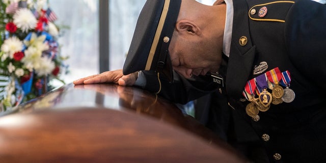 Sgt. Jose Burgos pauses for a moment at the casket of Vietnam veteran Peter Turnpu as several hundreds gather for a funeral Friday, Jan. 18, 2019 in Wrightstown, N.J. (Associated Press)