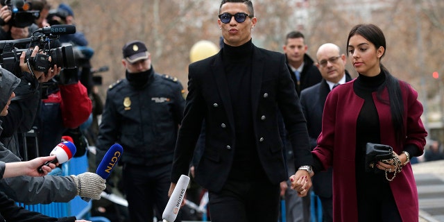 Cristiano Ronaldo arrives at the court in Madrid on Tuesday, Jan. 22, 2019. Cristiano Ronaldo is expected to plead guilty to tax fraud. The Juventus forward arrived in a black van, walked up some stairs leading to the court house and stopped to sign an autograph. The charges stem from his days at Real Madrid.