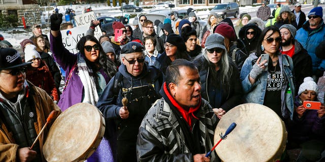A protestor leads a Native American prayer with a traditional drum outside the Catholic Diocese of Covington Tuesday, Jan. 22, 2019, in Covington, Ky. The diocese in Kentucky has apologized after videos emerged showing students from Covington Catholic High School mocking Native Americans outside the Lincoln Memorial on Friday after a rally in Washington. (AP Photo/John Minchillo)