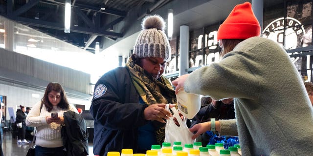 TSA worker Amelia Williams is given a bottle of milk at a food bank for government workers affected by the shutdown, Tuesday, Jan. 22, 2019, in the Brooklyn borough of New York. (AP Photo/Mark Lennihan)