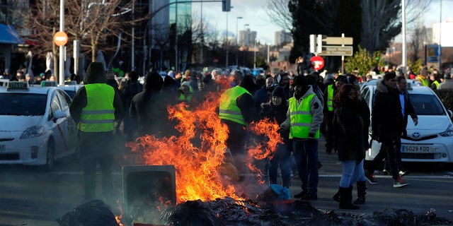 Striking Spanish taxi drivers demand more rules for app-based driving services blocking access to a trade exhibition center in Madrid, where a major tourism fair begins Wednesday
