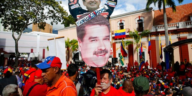 A supporter of Venezuela's President Nicolas Maduro carries a "Yankee Go Home" sign in Caracas on Wednesday. (AP Photo/Ariana Cubillos)