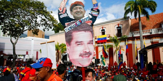 A supporter of Venezuela's President Nicolas Maduro carries a "Yankee Go Home" sign in Caracas on Wednesday. (AP Photo/Ariana Cubillos)