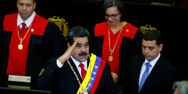 Venezuelan President Nicolas Maduro salutes as he arrives to the Supreme Court for an annual ceremony that marks the start of the judicial year in Caracas, Venezuela, Thursday, Jan. 24, 2019. Venezuelans are heading into uncharted political waters after the young leader of a newly united opposition claimed Wednesday to hold the presidency and Maduro dug in for a fight with the Trump administration. (AP Photo/Ariana Cubillos)