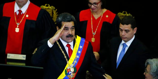 Venezuelan President Nicolas Maduro salutes as he arrives to the Supreme Court for an annual ceremony that marks the start of the judicial year in Caracas, Venezuela, Thursday, Jan. 24, 2019. Venezuelans are heading into uncharted political waters after the young leader of a newly united opposition claimed Wednesday to hold the presidency and Maduro dug in for a fight with the Trump administration. (AP Photo/Ariana Cubillos)