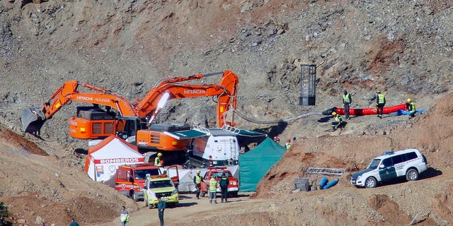 In this photo taken on Thursday, Jan. 24, 2019, drill and excavating machinery work on top of the mountain next to a deep borehole to reach a 2-year-old boy trapped there for twelve days near the town of Totalan in Malaga, Spain.