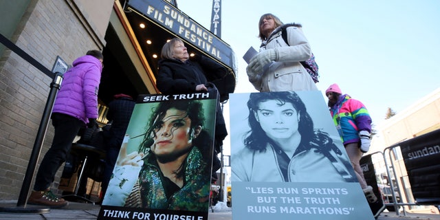 Brenda Jenkyns, left, and Catherine Van Tighem who drove from Calgary, Canada stand with signs outside of the premiere of the "Leaving Neverland" Michael Jackson documentary film at the Egyptian Theatre on Main Street during the 2019 Sundance Film Festival, Friday, Jan. 25, 2019, in Park City, Utah.