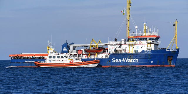 A Coast Guard boat approaches a German humanitarian group's rescue boat Sea Watch 3, to deliver food and blankets for the cold, off the coast of Syracuse, Italy, Sunday, Jan. 27, 2019. (AP Photo/Salvatore Cavalli)
