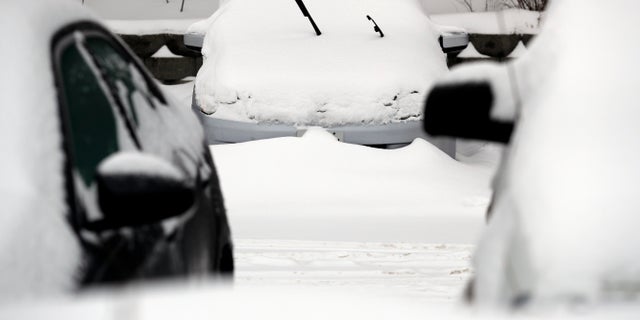 Cars are covered by snow on Monday in Wheeling, Ill. A winter storm brought more than 5 inches of snow to northern Illinois as the region braced itself for record-low subzero temperatures.