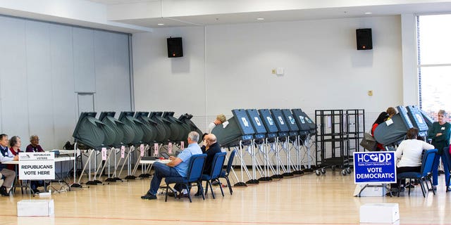 In this March 6, 2018, photo, voters take to the polls in the primary election at West University Elementary in Houston. The ACLU and other groups slammed Texas elections officials who say they found 95,000 people identified as noncitizens who had a matching voter registration record. Texas Attorney General Ken Paxton now says many of them could have become citizens and voted legally. (Brett Coomer/Houston Chronicle via AP, File)