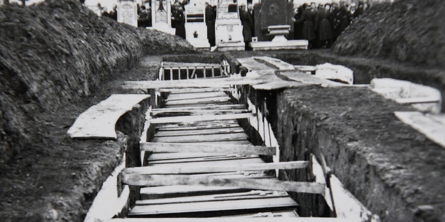 A photo taken on Decembre 5, 2018 in Villeneuve-d'Ascq, northern France, shows a reproduction of a photograph showing coffins after the massacre of Ascq in 1944 during WWII.