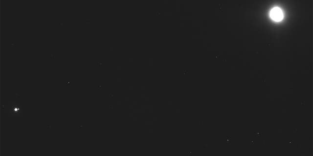 This image captured on Dec. 19, 2018, by a camera on the Osiris-Rex spacecraft shows the asteroid Bennu, top right, about 27 miles from the spacecraft, and the Earth and moon, bottom left, more than 70 million miles away. (NASA/Goddard/University of Arizona/Lockheed Martin Space via AP)