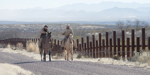 Howard Buffett speaking to a rancher whose property sits alongside border fencing in Arizona.